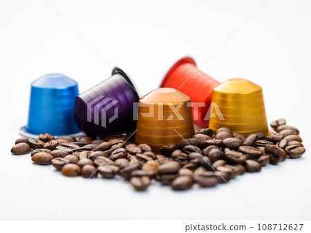 Aluminium capsules of natural organic coffee suitable with raw aroma bean on white background.Macro Aluminium capsules of natural organic coffee suitable with raw aroma bean on white background.Macro 108712627
