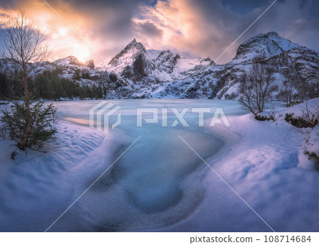 Frozen sea coast and rocks in snow at colorful sunset in winter Frozen sea coast and rocks in snow at colorful sunset in winter 108714684