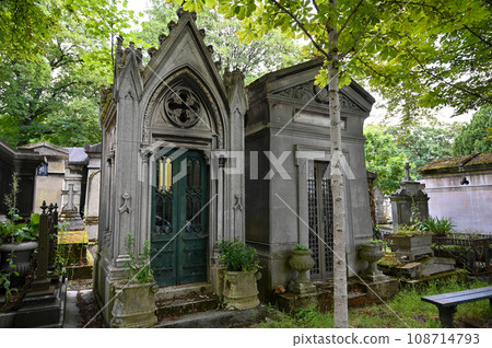 Paris, France. June 30, 2022. The characteristic and historic Pere-Lachaise cemetery, two dark-looking family tombs. Many personalities are buried here. 108714793