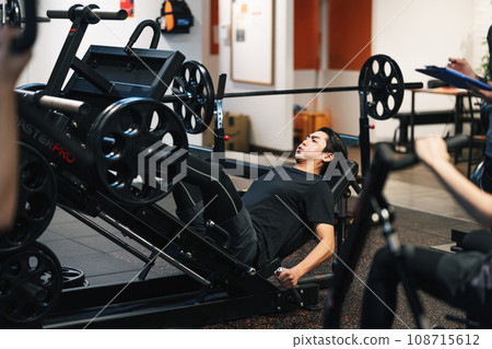 A man doing muscle training at a sports gym A man doing muscle training at a sports gym 108715612