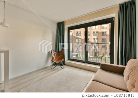 a living room with a couch, chair and window looking out onto the cityscapearrons com 108715915