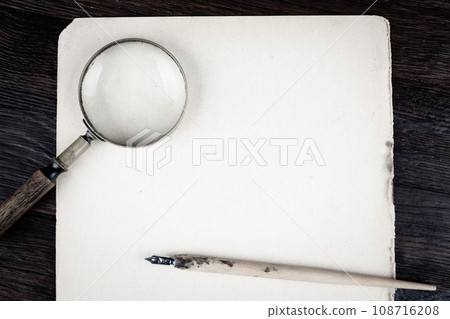 Magnifying glass with old paper and ink feather pen 108716208