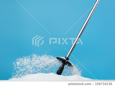 Trekking Poles put on snow ice. Telescopic trekking poles stick device for elderly people to walk with support protection hiking snow base in woods mountain. Blue sky winter background isolated 108716236