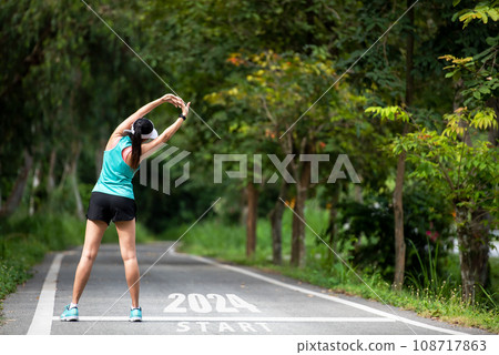 The start into the new year 2024. Start up of runner woman running on nature race track go to Goal  108717863