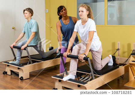 Teenagers training pilates in gym with trainer 108718281