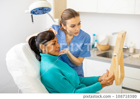 Positive woman evaluating quality of cosmetological procedures Positive woman evaluating quality of cosmetological procedures 108718380