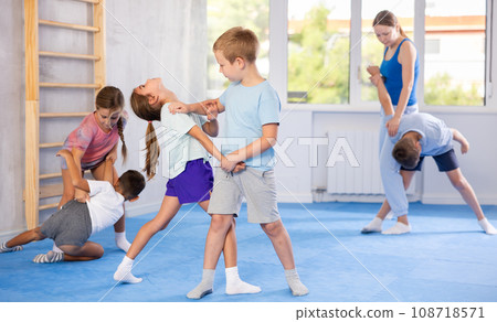 Girls and boys of performing protection with wring hands during training in self-defense Girls and boys of performing protection with wring hands during training in self-defense 108718571