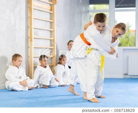 Children athletes in pair conduct training battle in oriental fighting technique 108718620