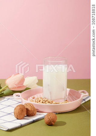 Few walnuts and soybeans are decorated with a cup filled with milk. Beans and nuts containing most of the vitamins and minerals the body needs Few walnuts and soybeans are decorated with a cup filled with milk. Beans and nuts containing most of the vitamins and minerals the body needs 108718818