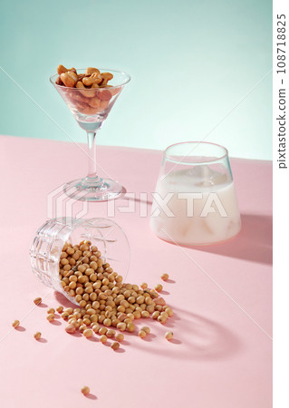 Cocktail glass contained some types nuts displayed with a cup of milk and a lot of soybeans. Soy milk supports a healthy heart from multiple angles 108718825