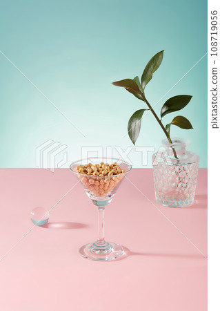 A lot of soybeans are contained inside a cocktail glass, decorated with a pot of green leaves. Soy milk contains plenty of antioxidants 108719056