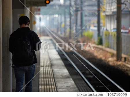 A man walking on a station platform during morning commuting hours A man walking on a station platform during morning commuting hours 108719099