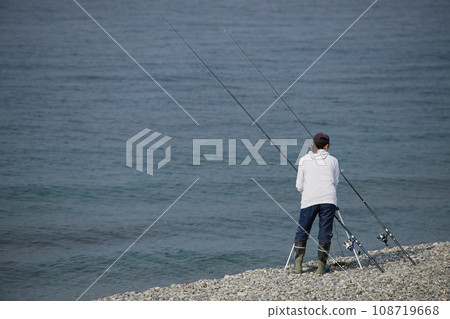 一位年輕女子早上在海灘上釣魚 108719668