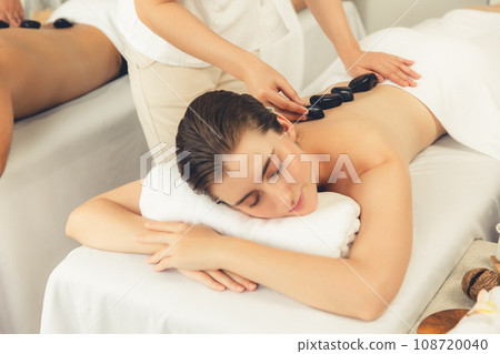 Hot stone massage at spa salon in luxury resort. Quiescent Hot stone massage at spa salon in luxury resort. Quiescent 108720040