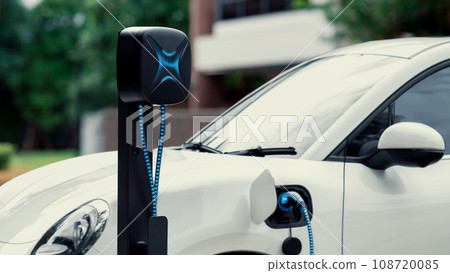 Electric car plugged in with home charging station. Peruse 108720085