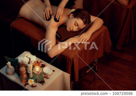 Hot stone massage at spa salon in luxury resort with warm candle light.Quiescent 108720086