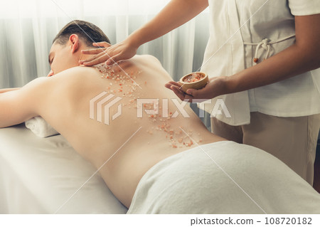 Blissful man customer having exfoliation treatment in luxury spa. Quiescent Blissful man customer having exfoliation treatment in luxury spa. Quiescent 108720182