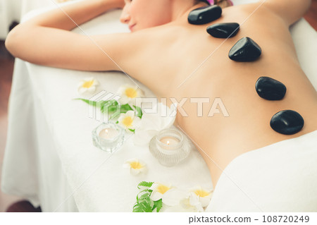 Hot stone massage at spa salon in luxury resort. Quiescent 108720249