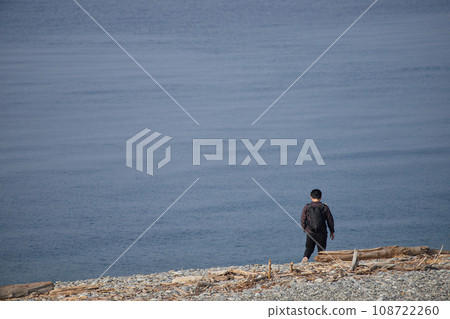 一個年輕人早上在海灘上散步 一個年輕人早上在海灘上散步 108722260