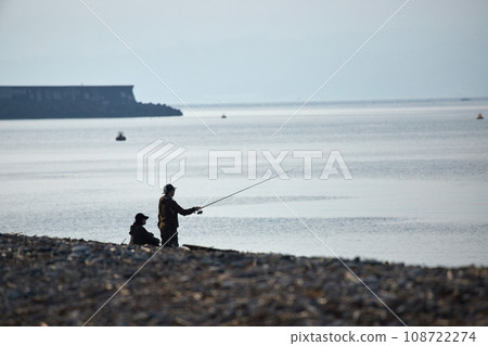 A young couple fishing on the beach in the morning 108722274
