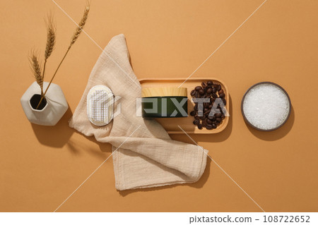 Minimal concept for advertising organic product with blank space for presentation. Natural ingredient, beans and powder of coffee decorated with cosmetic jar on wooden tray on brown background 108722652