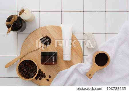 On the round wooden cutting board, set of cosmetic displayed with coffee beans and coffee powder. Bathroom concept with white tile background for advertising. Skin care beauty product packaging 108722665