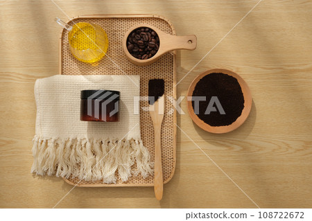 On the wooden background, a tray container cosmetic jar unlabeled, bowl and spoon of coffee, cup of honey and beige towel. Natural ingredients for body care, cleansing and exfoliating products 108722672