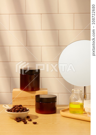 Front view of set of cosmetic jar displayed on white tile background with bowl of coffee beans and small mirror. Mockup for set of product for body care with ingredient from coffee 108722680