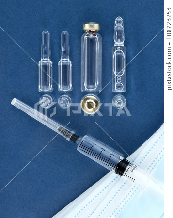 Syringe, ampoules and face mask ampules over desk, top view, copy space. 108723253