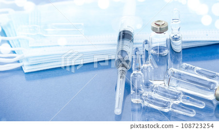 Syringe, ampoules and face mask on the medical table, close-up. 108723254