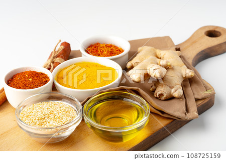 Ginger root and various spices on white background Ginger root and various spices on white background 108725159