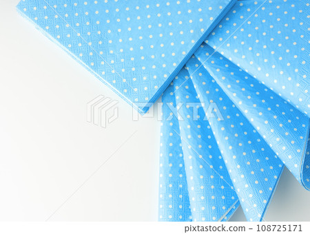Stack of blue dotted paper napkins isolated on white 108725171