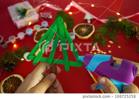 Step by step instruction how to make christmas tree from ice cream sticks. Step 3 glue sticks together. Children's New year handmade craft Step by step instruction how to make christmas tree from ice cream sticks. Step 3 glue sticks together. Children's New year handmade craft 108725258