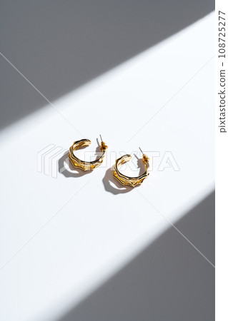 Golden earrings on white background studio shot Golden earrings on white background studio shot 108725277
