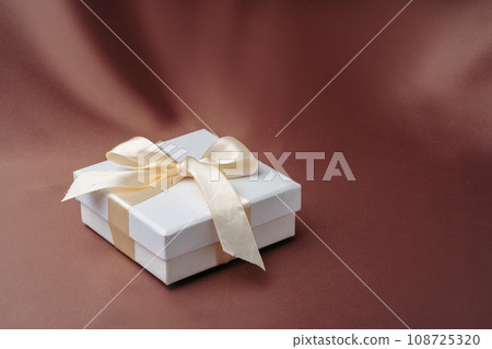 White jewelry boxes on brown silk background 108725320
