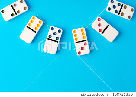Domino tiles on blue background studio shot Domino tiles on blue background studio shot 108725330