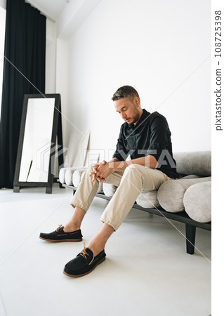 Portrait of a man in black shirt posing in photostudio Portrait of a man in black shirt posing in photostudio 108725398