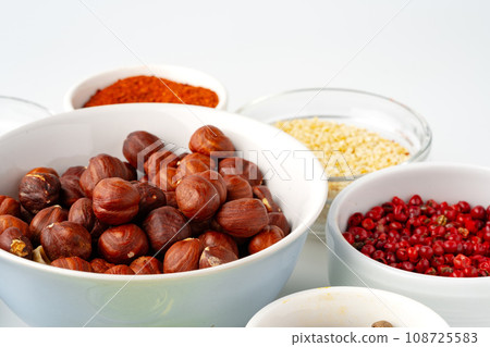 Bowls with spices and cooking ingredients on white background Bowls with spices and cooking ingredients on white background 108725583