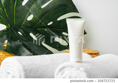 lank cosmetic bottles and towels on gray background 108725725