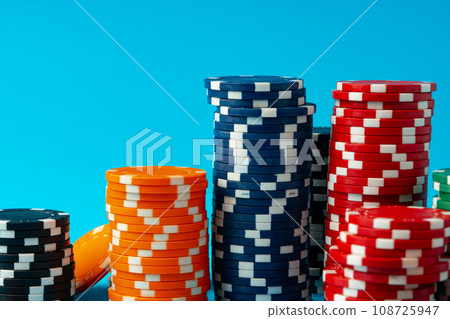 Stacks of poker chips on blue background Stacks of poker chips on blue background 108725947