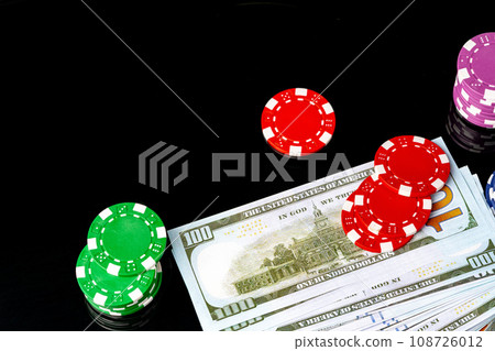 Poker chips and dollar bills on black background studio shot Poker chips and dollar bills on black background studio shot 108726012