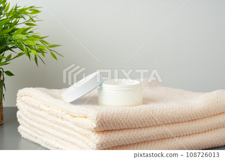 White cosmetics container mockup with towels on gray background 108726013