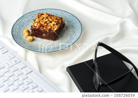 Piece of brownie cake with hazelnuts on white background 108726039
