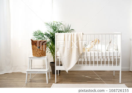 Muslin baby blanket hanging on child's bed in nursing room Muslin baby blanket hanging on child's bed in nursing room 108726155