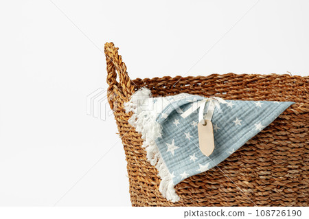 Soft cotton blanket in a straw basket on white background Soft cotton blanket in a straw basket on white background 108726190