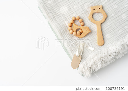 Muslin swaddle blanket with wooden toys on white background 108726191
