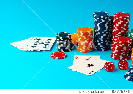 Playing cards and poker chips on blue background Playing cards and poker chips on blue background 108726226