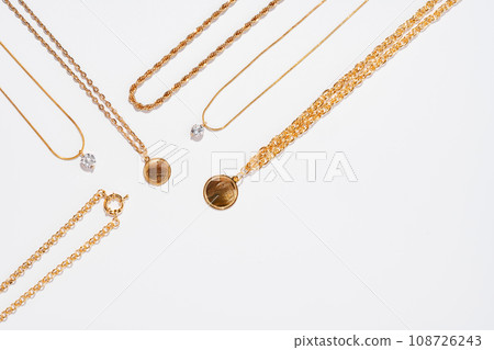 Set of gold chains with pendant on white background 108726243
