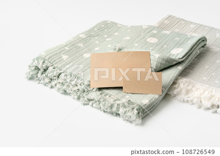 Warm cotton muslin blanket with paper tag on white background Warm cotton muslin blanket with paper tag on white background 108726549