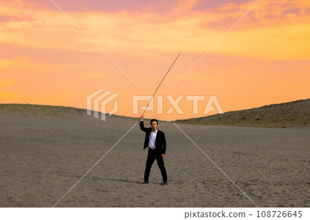 A person trying to throw a spear in the sunset-stained desert A person trying to throw a spear in the sunset-stained desert 108726645